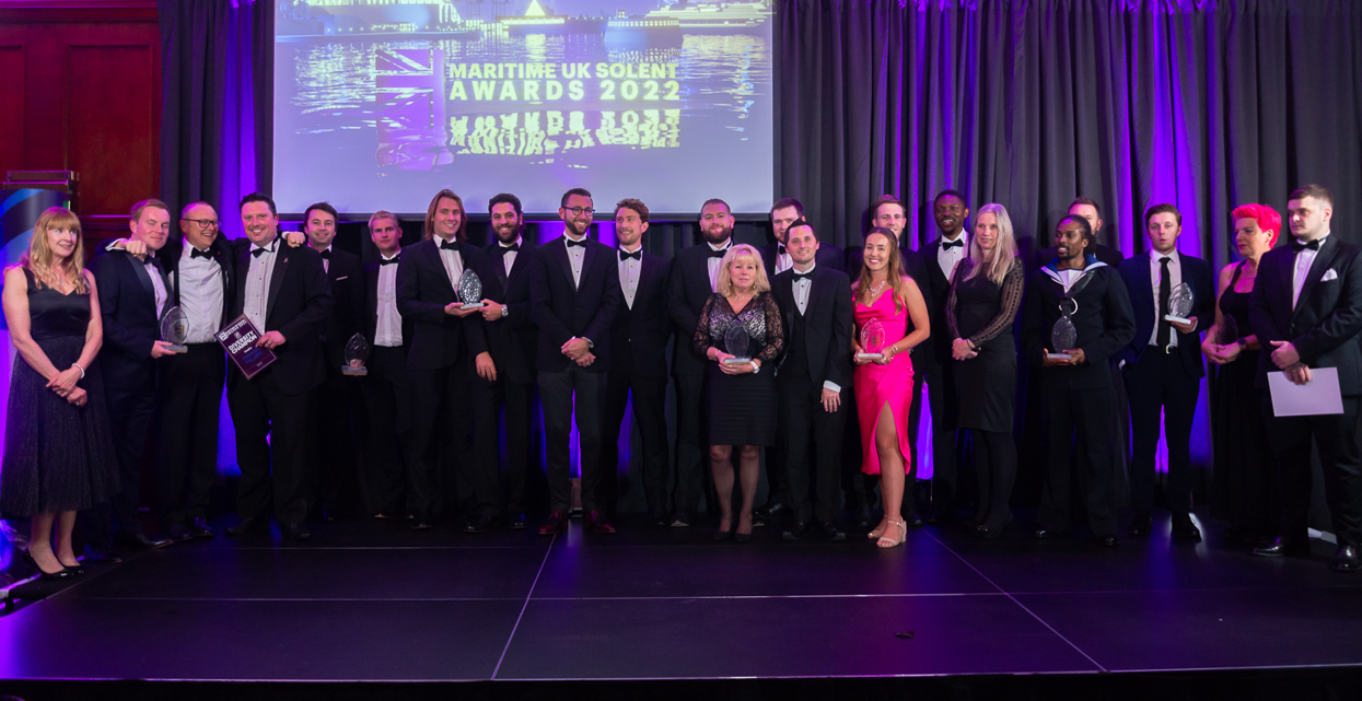 A photo of Maritime UK Solent Awards 2022 Finalists on stage with a purple curtain in the background and a tv screen showing the awards logo image