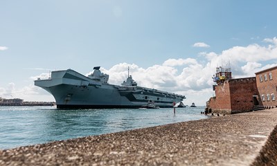 A photo of a Royal Navy ship near the shore.