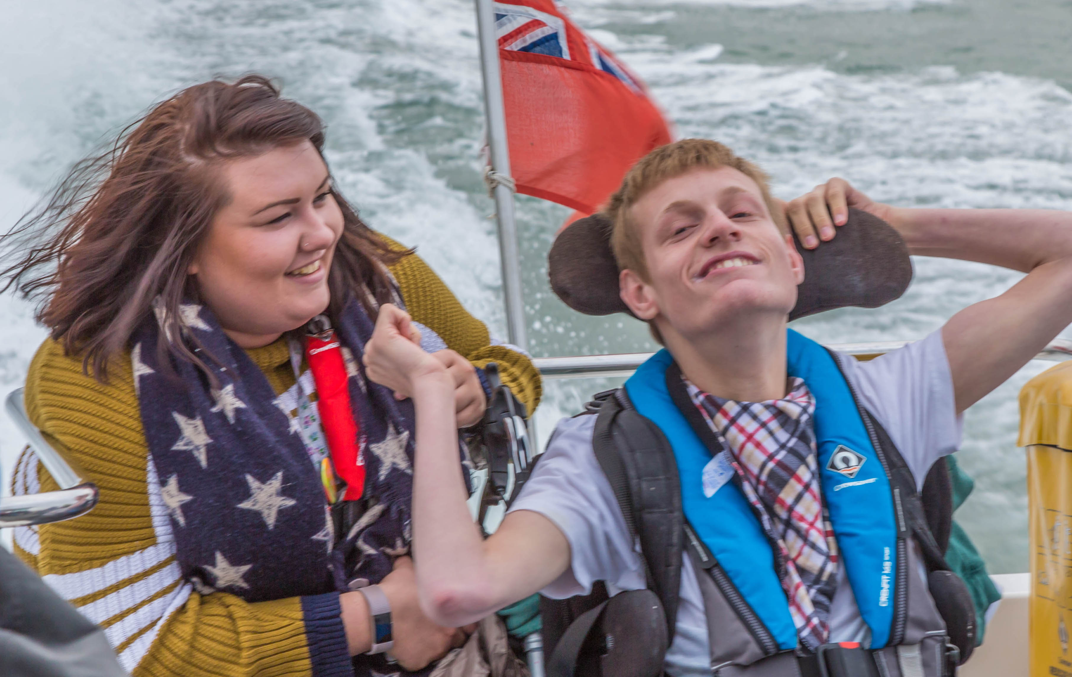 A photo of a WetWheels Charity volunteer and a young person on a boat taking a trip